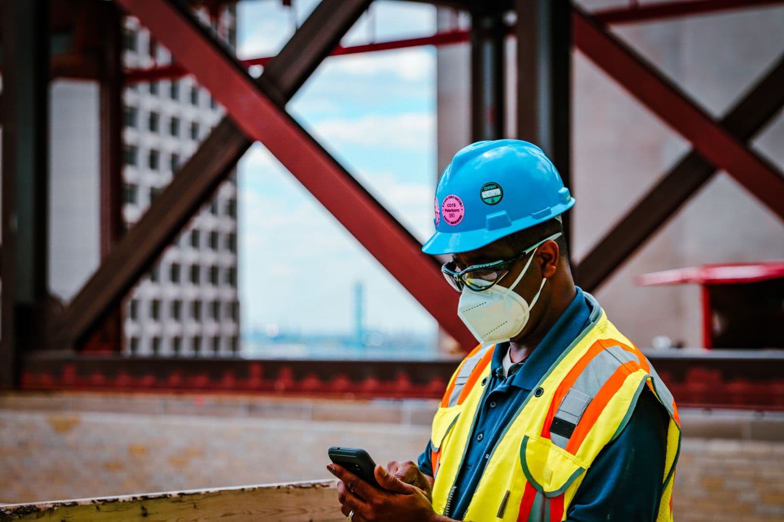 A builder on site checking subcontractor compliance on their phone